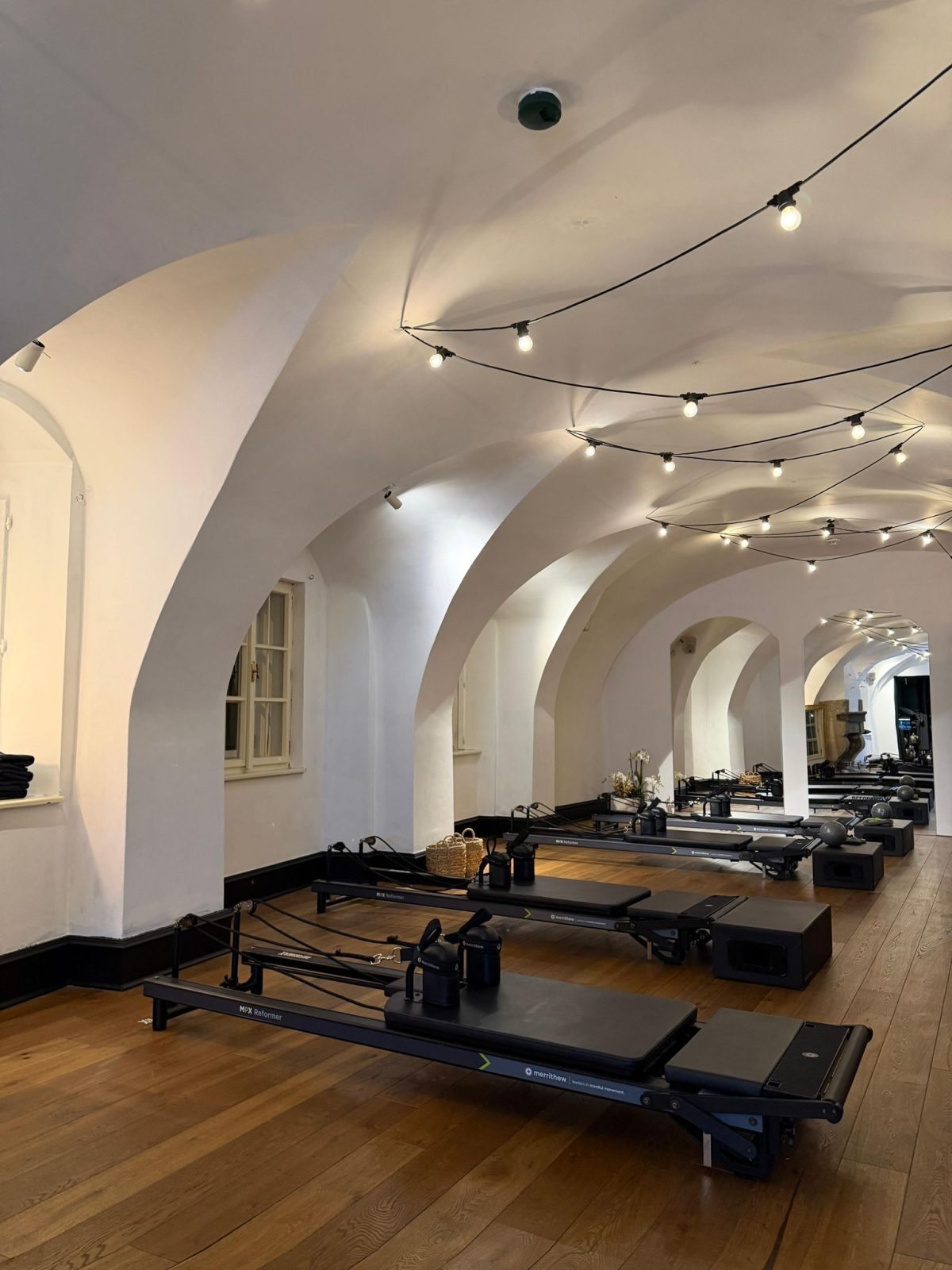 Studio RX Pilates v Praze, prázdný sál s klenutým stropem a Reformery